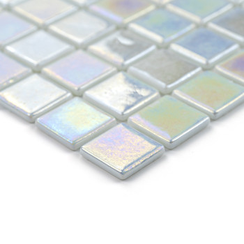 Iridescent glass tiles shimmer, arranged in a grid pattern, creating a reflective, colorful mosaic on a smooth surface.
