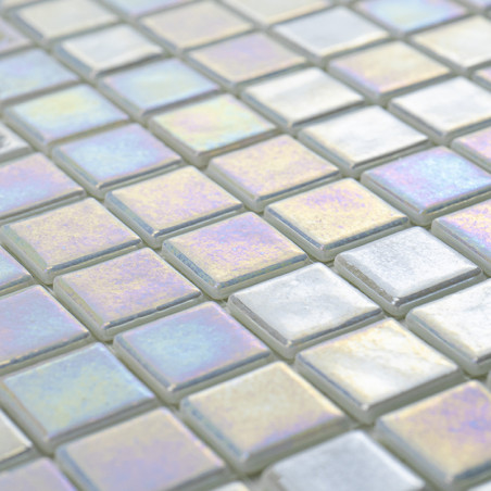 Square glass tiles shimmer, reflecting rainbow colors in soft light, forming a patterned surface with subtle color variations.