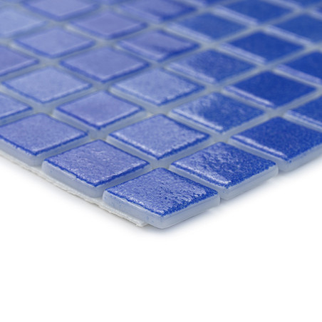 Blue square tiles form a glass mosaic, reflecting light, arranged in a grid pattern on a flat surface.
