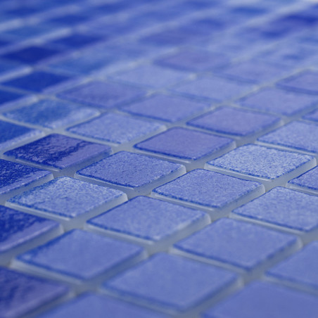 Blue glass tiles form a textured mosaic pattern, creating a shimmering surface in a softly illuminated space.