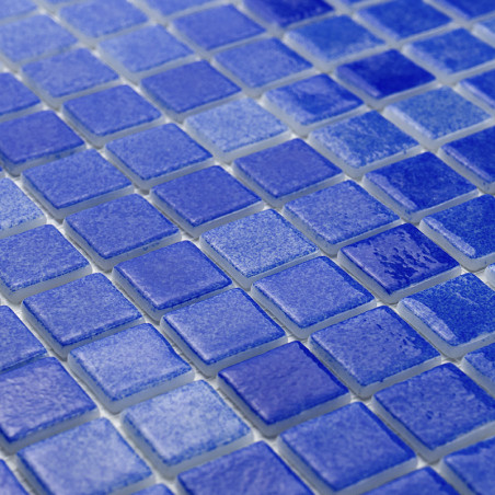 Glazed blue glass tiles arranged systematically, creating a textured, reflective surface in a grid pattern.