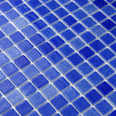 Blue glass tiles forming a mosaic pattern, creating a textured surface, possibly for a wall or floor.