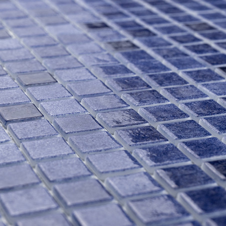 Los pequeños azulejos de vidrio azul crean un mosaico brillante que refleja la luz en varios tonos y evoca una tranquila escena 