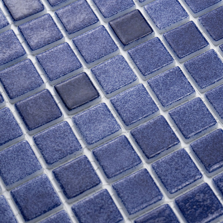 Los azulejos de vidrio azul forman un patrón uniforme, creando una superficie texturizada en una disposición de mosaico en forma