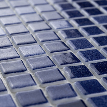 Blue square tiles form a grid pattern, creating a textured surface in a subtle gradient within an interior setting.