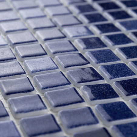 Blue square tiles form a grid pattern, creating a textured surface in a subtle gradient within an interior setting.