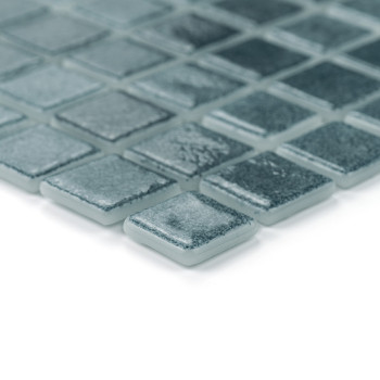 Square glass tiles arranged neatly, reflecting light subtly, in a grid pattern against a smooth white background.