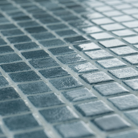 Blue glass tiles evenly arranged, reflecting light, create a shimmering effect in a grid-like pattern.