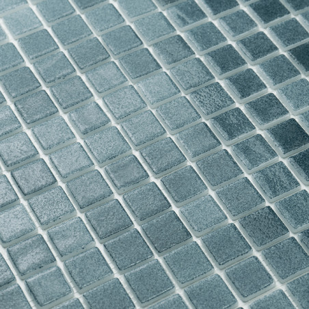Square glass tiles align neatly, forming a textured pattern. They glimmer subtly, set against a uniform grid layout.