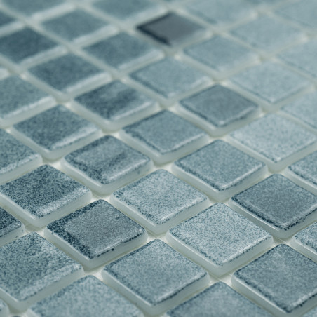 Square glass tiles shimmer subtly, reflecting light across a grid, creating a textured, uniform mosaic pattern.