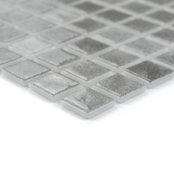 Square glass tiles rest in a grid pattern, reflecting light subtly in a minimalistic, modern setting.