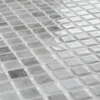 Square tiles glimmer, arranged in uniform rows, creating a reflective surface pattern in a neutral-toned mosaic design.