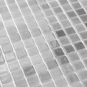 Glass tiles form a shiny, textured grid pattern, reflecting light subtly in a monochromatic, neutral-toned layout.