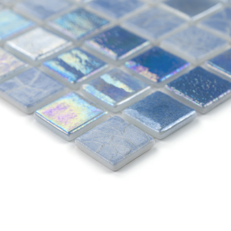 Square glass tiles reflect light, displaying iridescent blue and silver hues, arranged in a neat, geometric pattern.