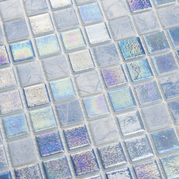 Iridescent glass tiles shimmer, reflecting multicolored light amidst a grid of matte, stone-like squares in a mosaic pattern.