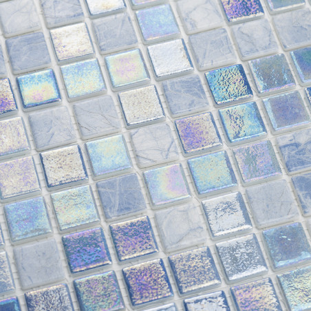 Iridescent glass tiles shimmer, reflecting multicolored light amidst a grid of matte, stone-like squares in a mosaic pattern.