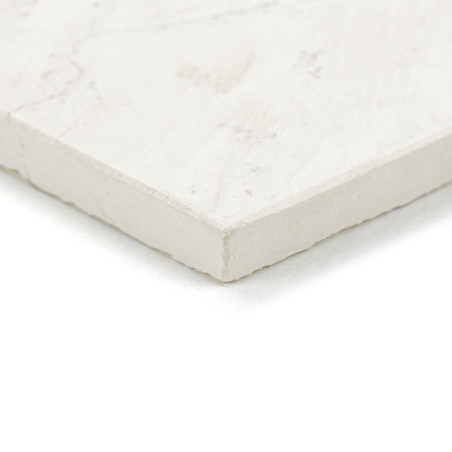 Rectangular stone tile rests on a flat surface, displaying a smooth, light-colored texture with subtle marbling patterns.