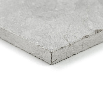 A textured, gray stone tile lies on a white surface, displaying its rough edges and smooth top.