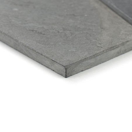 A smooth, rectangular stone tile lies flat, revealing a gray textured surface with subtle patterns, resting on a white backgroun