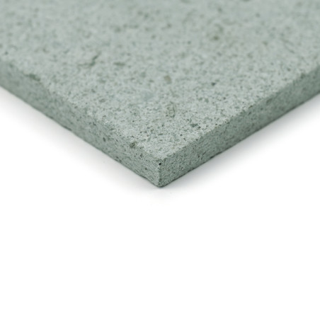 Gray stone tile displays a textured, speckled surface. rests on a smooth white background, showcasing its thickness and detail.