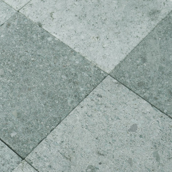 Gray stone tiles form a checkered pattern, alternating shades, creating a textured, industrial floor surface.