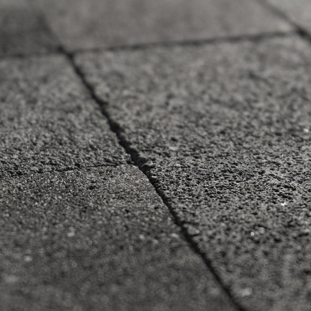 Rough stone tiles lie in alignment, forming a textured pattern, creating a uniform surface in a close-up view.