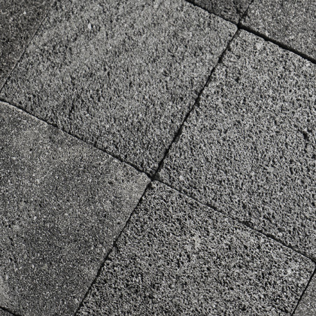 Gray stone tiles form a grid pattern, displaying a rough texture, aligned neatly in an outdoor setting.