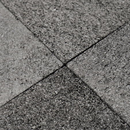 Gray stone tiles form a textured, interlocking pattern on a flat surface, creating a uniform, durable floor.