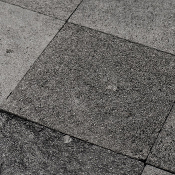 Gray stone tiles form a textured, uneven surface in a geometric pattern, conveying a natural, rustic aesthetic.