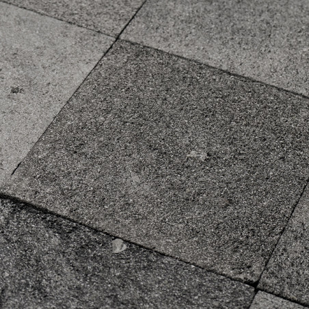 Gray stone tiles form a textured, uneven surface in a geometric pattern, conveying a natural, rustic aesthetic.