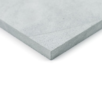 Gray stone tile, lying flat, displaying a textured corner. photographed against a white background.