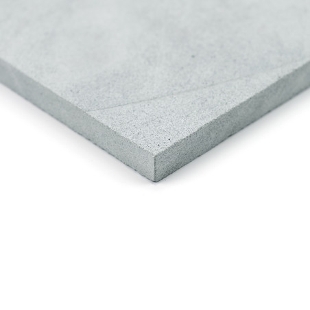 Gray stone tile, lying flat, displaying a textured corner. photographed against a white background.
