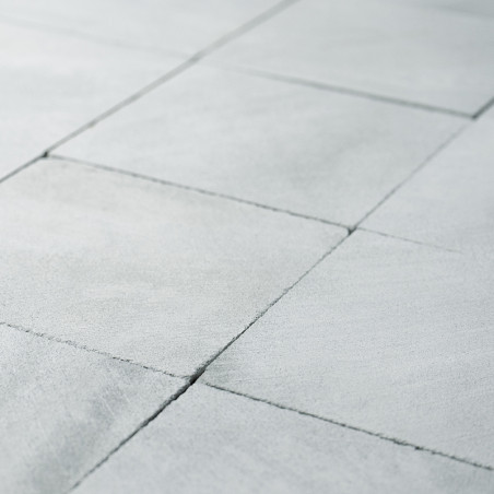 Gray stone tiles form a geometric pattern, intersecting cleanly, creating a smooth, consistent surface in an architectural setti