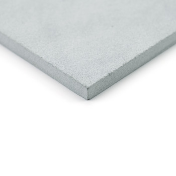 A smooth, gray stone tile sits angled slightly upward, highlighting its textured, precise edge against a plain, white background