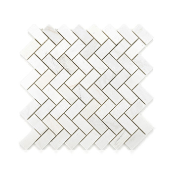 White rectangular marble tiles are arranged in a herringbone pattern, forming an interlocking geometric design on a flat surface