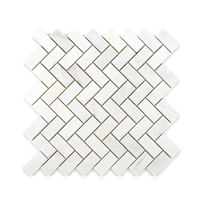 White rectangular marble tiles are arranged in a herringbone pattern, forming an interlocking geometric design on a flat surface