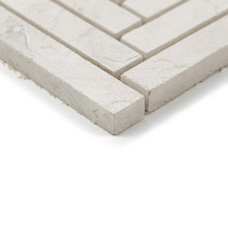 Rectangular stone tiles are aligned precisely, forming a grid pattern on a flat, neutral-colored surface.