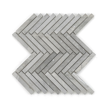 Gray stone tiles form a zigzag pattern, neatly arranged to create a continuous chevron design on a plain surface.