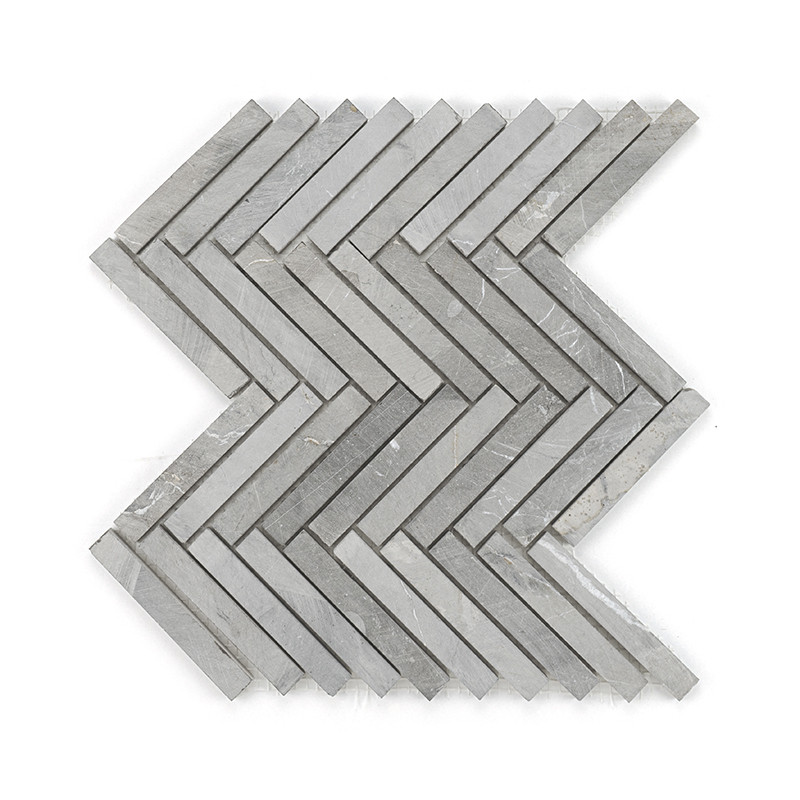 Gray stone tiles form a zigzag pattern, neatly arranged to create a continuous chevron design on a plain surface.