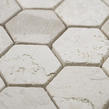 Hexagonal stone tiles form a textured pattern, with rough white surfaces and subtle gray veins, closely arranged.
