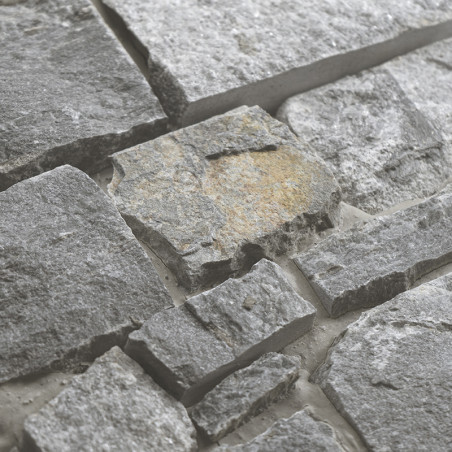 Rough gray stone tiles interlock, forming a textured surface. set in a light grout for an earthy, natural appearance.