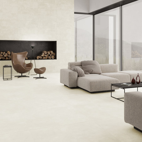Een moderne woonkamer is voorzien van een grote beige sectionele bank met uitzicht op een strakke, zwarte open haard, met daarin