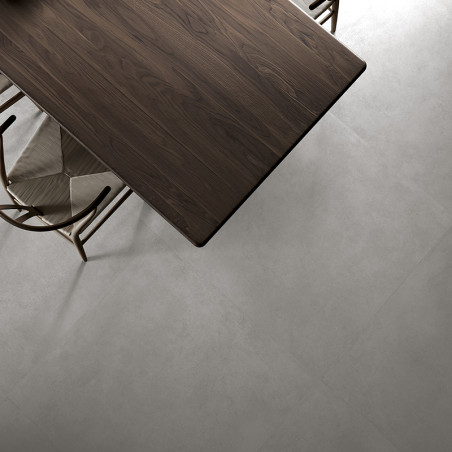 Een donkerhouten tafel staat bovenop een lichtgrijze, gladde tegelvloer, omgeven door beige stoffen stoelen, waardoor een modern