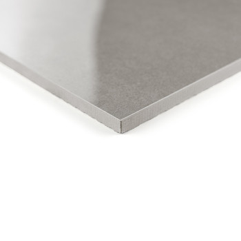 Un azulejo gris elegante y brillante descansa en ángulo, mostrando una superficie lisa y reflectante. Se encuentra sobre un fond