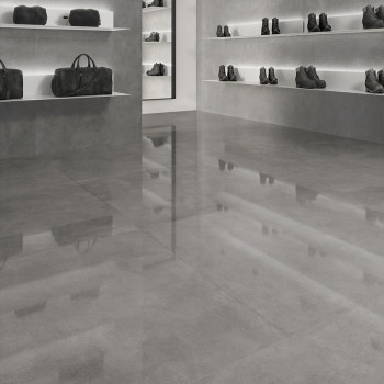 El piso de azulejos grises brilla, reflejando un entorno minorista con estantes que exhiben bolsos y botas de cuero oscuro contr