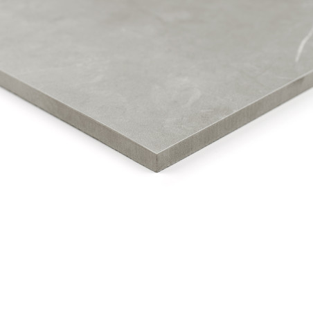 Um revestimento cerâmico liso e cinza repousa sobre uma superfície branca, exibindo sua borda limpa e angular, sugerindo um desi