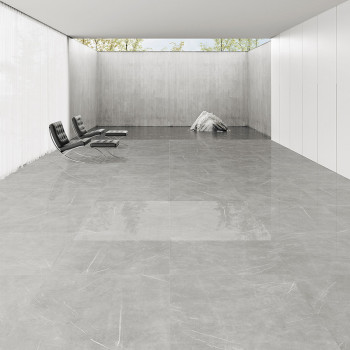 Piso de mármore cinza refletindo a luz, situado em uma sala minimalista com paredes brancas e cadeiras pretas modernas, com peça