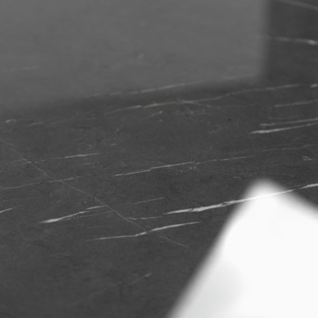 Les carreaux de marbre foncé présentent de subtiles veines blanches, reflétant une lumière douce sur une surface lisse et polie 
