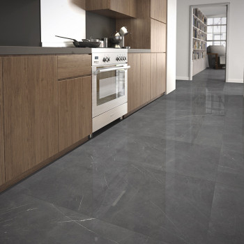 Des carreaux gris brillants recouvrent le sol, reflétant la lumière dans une cuisine moderne avec des armoires en bois et des ap