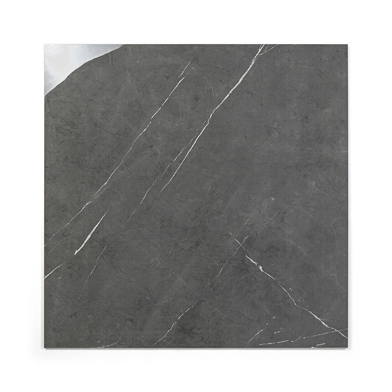 Un carreau carré présente une surface gris foncé avec de fines veines diagonales blanches, ressemblant à de la pierre naturelle,